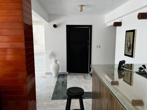 una cocina con una puerta negra y un taburete en Exclusiva y privada Villa en Marina Las Brisas, en Acapulco