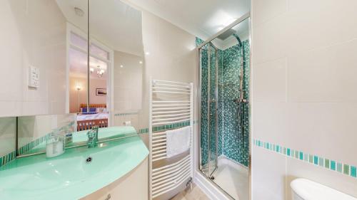 a bathroom with a sink and a tub and a shower at Harbour Lights in Exmouth