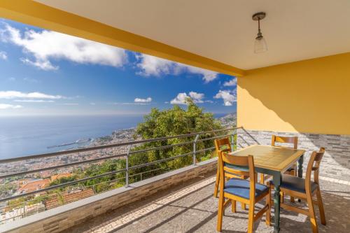 a table and chairs on a balcony with a view of the ocean at Villa Nobrega by Holiday Rental Madeira in Funchal
