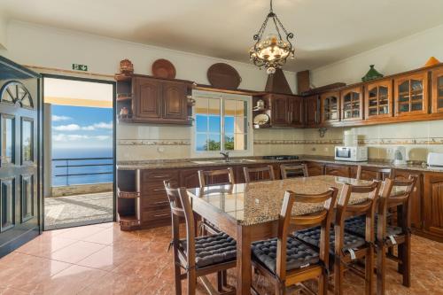 a kitchen with a table and chairs and the ocean at Villa Nobrega by Holiday Rental Madeira in Funchal