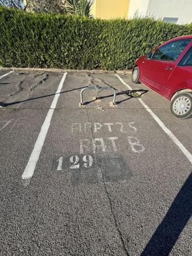 une voiture rouge est garée dans un parking dans l'établissement Appartement - Cap d'Agde, au Cap d'Agde