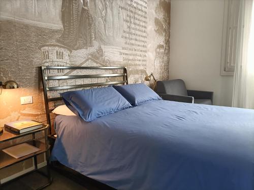 a bedroom with a blue bed and a wall at BB LETTERARIO in Ravenna