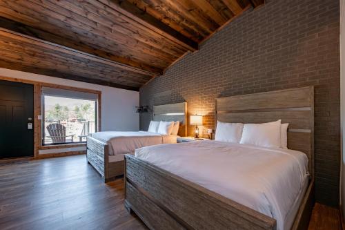 a bedroom with two beds and a brick wall at Cove Creek Lodge 203 Poolside Double Queen Room in Oakland