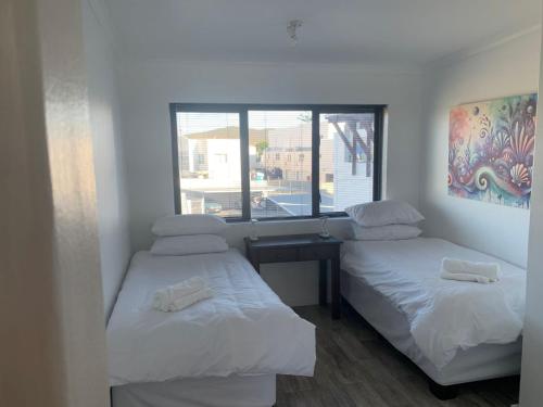 due letti in una stanza con finestra di At Sea, Melkbosstrand a Melkbosstrand