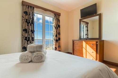 a bedroom with a bed with a mirror and a dresser at Villa Nobrega by Holiday Rental Madeira in Funchal
