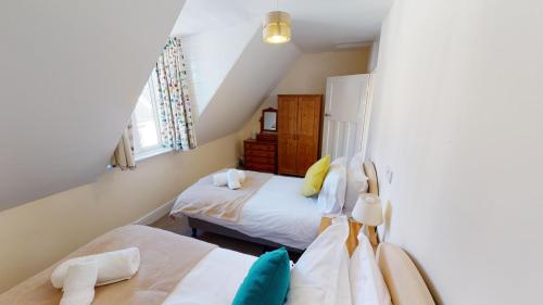 ein Schlafzimmer mit zwei Betten und einem Fenster in der Unterkunft Holmdean Cottage in Sidmouth