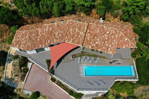  Elle offre une vue sur une grande maison dotée d'une piscine. dans l'établissement Villa Eden pour 8 personnes climatisée avec piscine chauffée et vue mer à La Londe-les-Maures, à La Londe-les-Maures