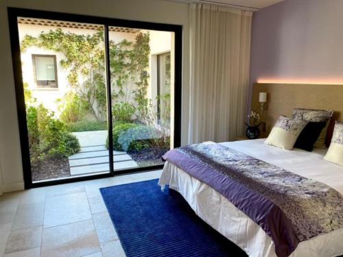 ein Schlafzimmer mit einem großen Bett und einem großen Fenster in der Unterkunft Villa Qalaisie - Luxury Villa for 16 on Terre Blanche Golf Estate in Tourrettes