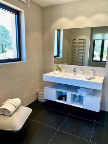 une salle de bain avec un lavabo blanc et un miroir dans l'établissement Villa Qalaisie - Luxury Villa for 16 on Terre Blanche Golf Estate, à Tourrettes