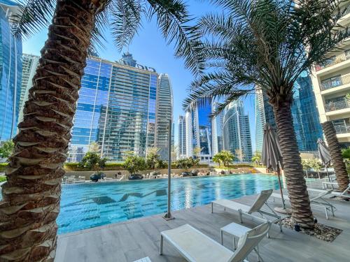 a swimming pool with palm trees and buildings at Dubai Burj KHALIFA VIEW SMART HOME ZADA TOWER in Dubai