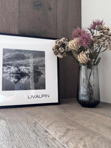 a vase with flowers in it next to a picture at LIVALPIN 2Enjoy in Garmisch-Partenkirchen