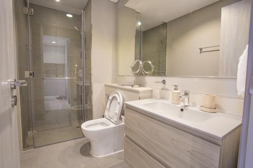 a bathroom with a toilet and a sink and a shower at Burj KHALIFA VIEW SMART HOME ZADA TOWER in Dubai