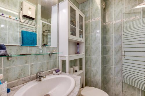 une salle de bain avec un lavabo et des toilettes dans l'établissement Appartement - La Conque, au Cap d'Agde
