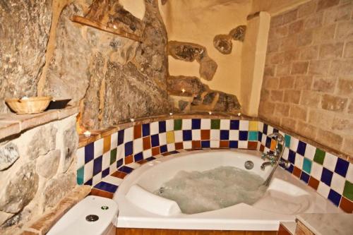 eine Badewanne im Bad mit einer Steinmauer in der Unterkunft La Casa Mora in Jérica