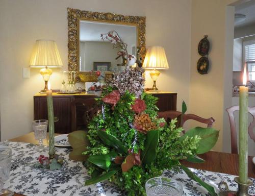 a table with a flower arrangement in front of a mirror at Virginia Country Cottage, GREAT Location, Pets in Troutville