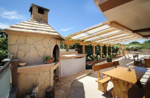 a outdoor kitchen with a table and a stone building at Ana & Marija in Kaštela