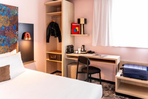 a hotel room with a bed and a desk at Ibis Styles Dijon Nord Valmy in Dijon