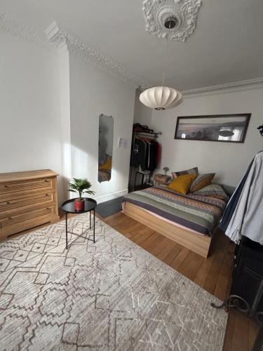 une chambre avec un lit et une table dedans dans l'établissement Grand appartement à Paris - Porte de Versailles, à Issy-les-Moulineaux