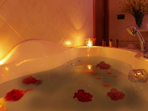 a bath tub with candles and red flowers in it at Locanda Del Parco Hotel in Colledara