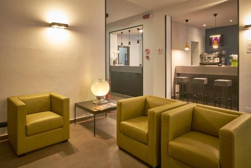 uma sala de espera com duas cadeiras amarelas e uma mesa em Smart Hotel em Carpi
