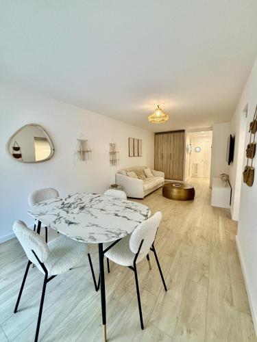 un salon avec une table, des chaises et un canapé dans l'établissement Résidence Neptunia, à Juan-les-Pins