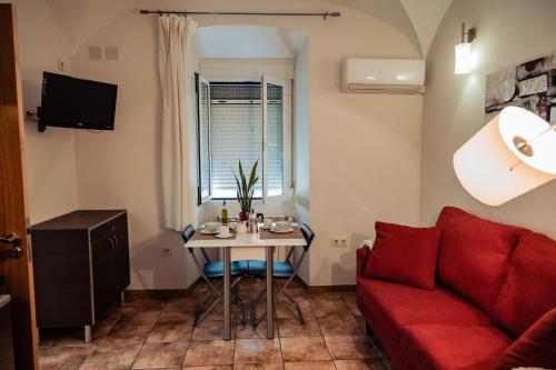 a living room with a red couch and a table at Apartamento Las Avutardas 1 in Cáceres
