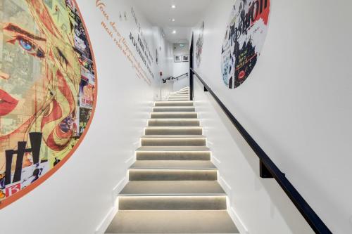 un escalier dans un musée avec des œuvres d'art sur les murs dans l'établissement Bluestay 78 - Superb apartment, à Paris