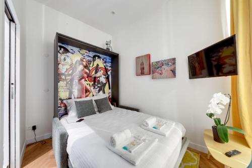 une chambre avec un lit blanc avec une grande affiche sur le mur dans l'établissement Bluestay 78 - Superb apartment, à Paris