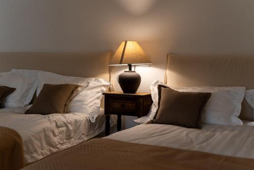 a bedroom with two beds and a lamp on a night stand at Tonight Homestay West Nanjing Road Shanghai in Shanghai