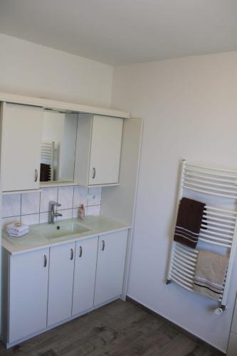 a white bathroom with a sink and a mirror at Ferienhaus Rosenberg in Jandelsbrunn