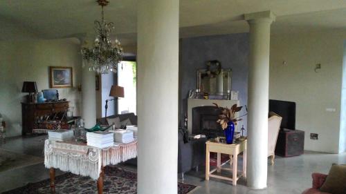 a living room with columns and a living room with a fireplace at Agriturismo CASA DELLE VIOLE in Fornovo di Taro