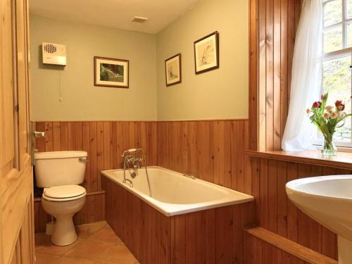 a bathroom with a tub and a toilet and a sink at The Coach House in Lochailort