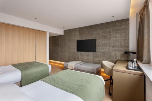 a hotel room with two beds and a flat screen tv at Royal Garden Hotel in London