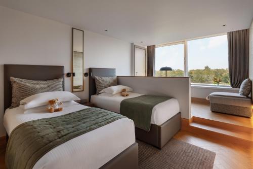 a hotel room with two beds and a window at Royal Garden Hotel in London