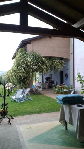 a patio with a table and chairs on the grass at Agriturismo CASA DELLE VIOLE in Fornovo di Taro