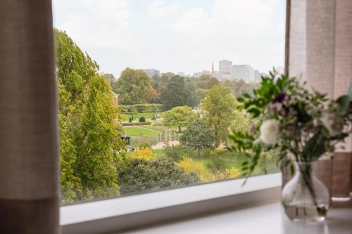 a window with a vase of flowers on a table at Royal Garden Hotel in London
