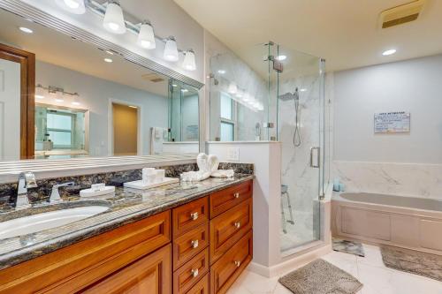 a bathroom with a tub and a sink and a shower at Lamplighter Cove in Marco Island
