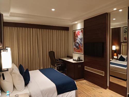 a hotel room with a bed and a desk at Best Western Swaran Amritsar in Amritsar