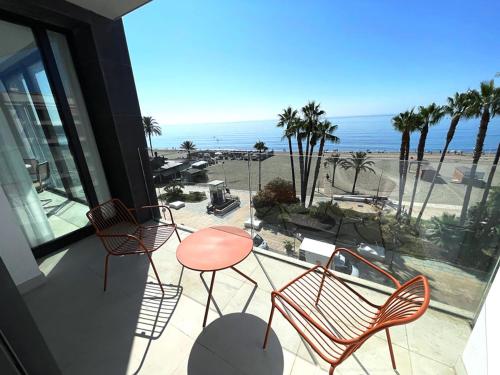 a balcony with chairs and a table and a view of the beach at Apartamento LaViu 1B by Croma in Estepona