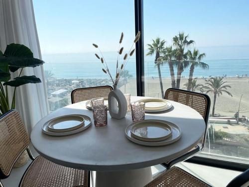 a table with plates and a vase on top of it at Apartamento LaViu 1B by Croma in Estepona