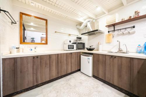a kitchen with wooden cabinets and a sink and a mirror at Tonight Homestay West Nanjing Road Shanghai in Shanghai