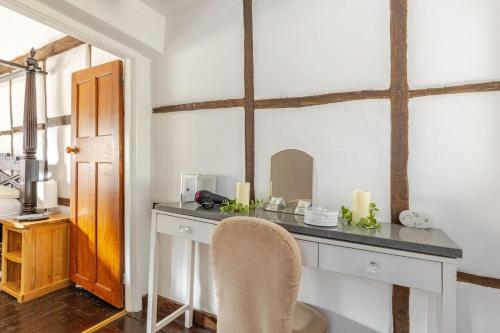 Zimmer mit einem Schreibtisch mit Stuhl und Kerzen in der Unterkunft Beautiful 17th Century Cottage in Buckinghamshire