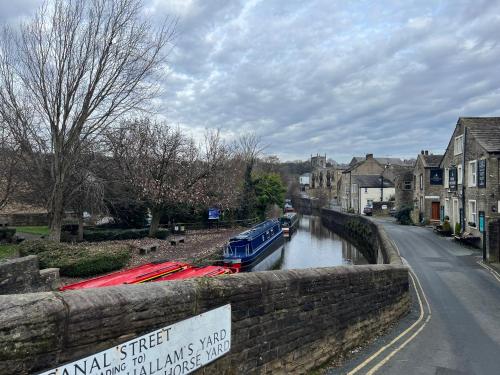 a river with boats on it in a town at The Boat in Skipton