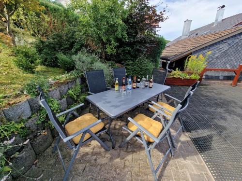 a table and chairs with bottles and drinks on it at Ferienwohnung Strohbergblick in Schichtshöhn