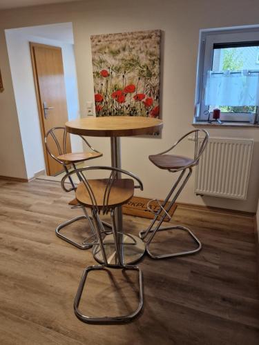 a table and chairs in a room with a painting at Ferienwohnung Strohbergblick in Schichtshöhn