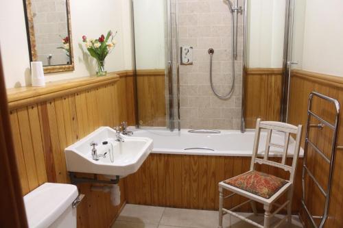 a bathroom with a tub and a sink and a shower at Glenfield in Lochailort