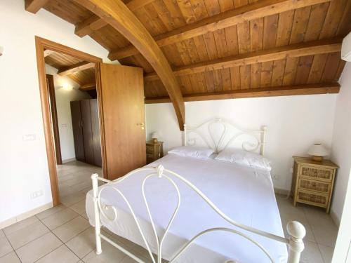 a white bed in a room with a wooden ceiling at Isca Dreams T6 in Isca sullo Ionio