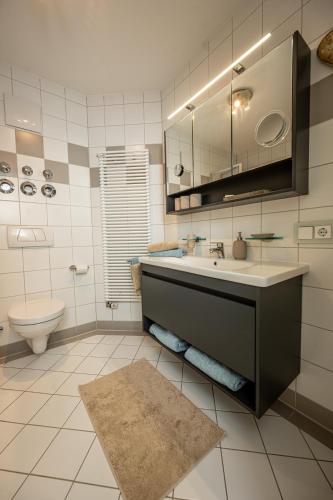 a bathroom with a sink and a toilet at Ferienwohnung Marianne Bergpanorama für Paare 60qm in Berchtesgaden