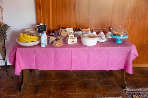 a table with a pink table cloth with food on it at A Casa di Sara in Castrovillari