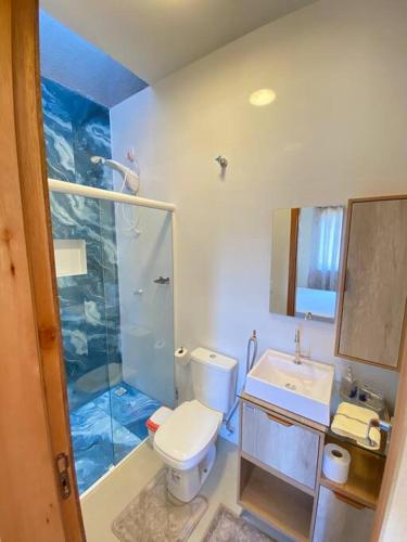 a bathroom with a shower and a toilet and a sink at Casa confortável perto da praia in Guaratuba